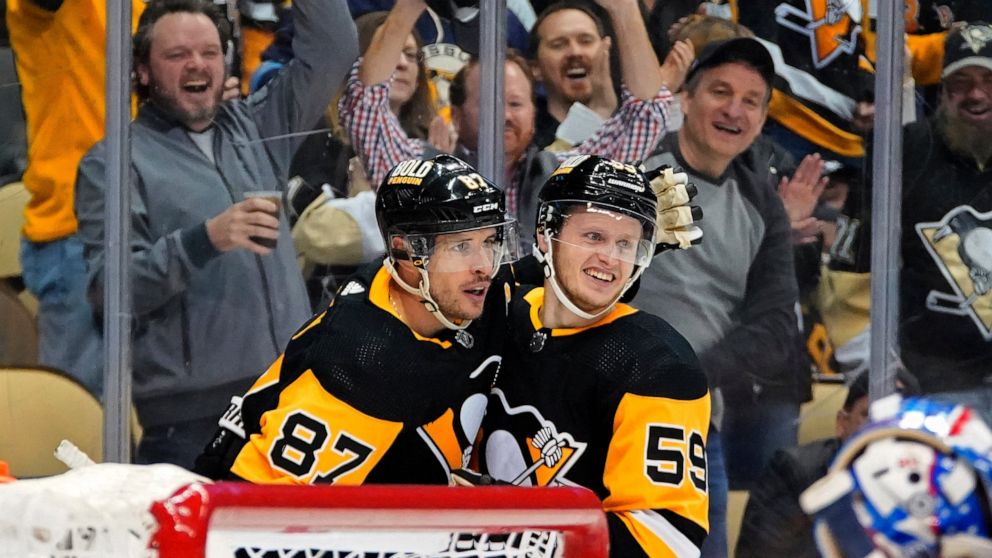Pittsburgh Penguins' Jake Guentzel (59) celebrates his goal with Sidney Crosby, who assisted, during the second period of the team's NHL hockey game against the Columbus Blue Jackets in Pittsburgh, Tuesday, March 22, 2022. (AP Photo/Gene J. Puskar)