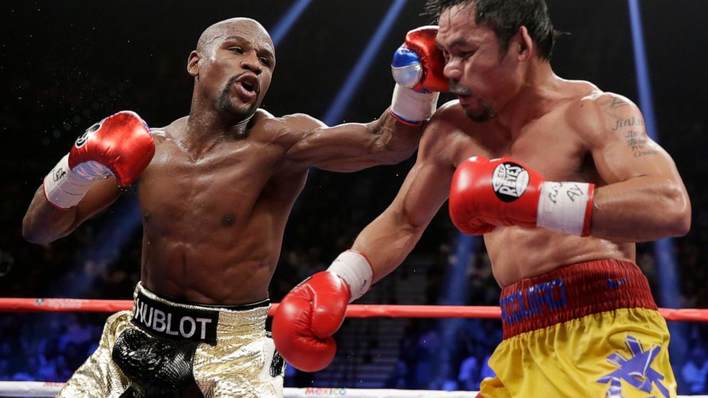 FILE - Floyd Mayweather Jr., left, hits Manny Pacquiao, from the Philippines, during their welterweight title fight on Saturday, May 2, 2015, in Las Vegas. Mayweather Jr. will be inducted into the Boxing Hall of Fame in Canastota, N.Y., on Sunday, Ju