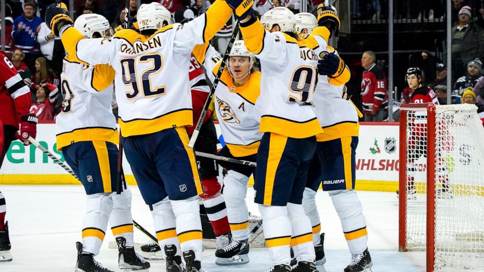 Nashville Predators center Mikael Granlund (64), center Ryan Johansen (92), center Matt Duchene (95) and others celebrate following the game-tying goal late in the third period of the team's NHL hockey game against the New Jersey Devils, Thursday, De