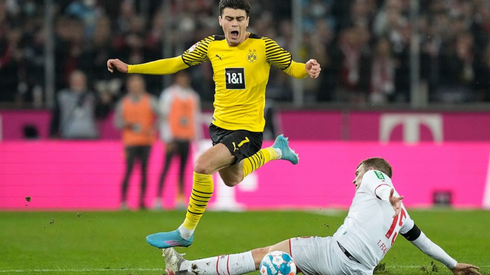 Dortmund's Giovanni Reyna, left, and Cologne's Luca Kilian challenge for the ball during the German Bundesliga soccer match between 1.FC Cologne and Borussia Dortmund in Cologne, Germany, Sunday, March 20, 2022. (AP Photo/Martin Meissner)