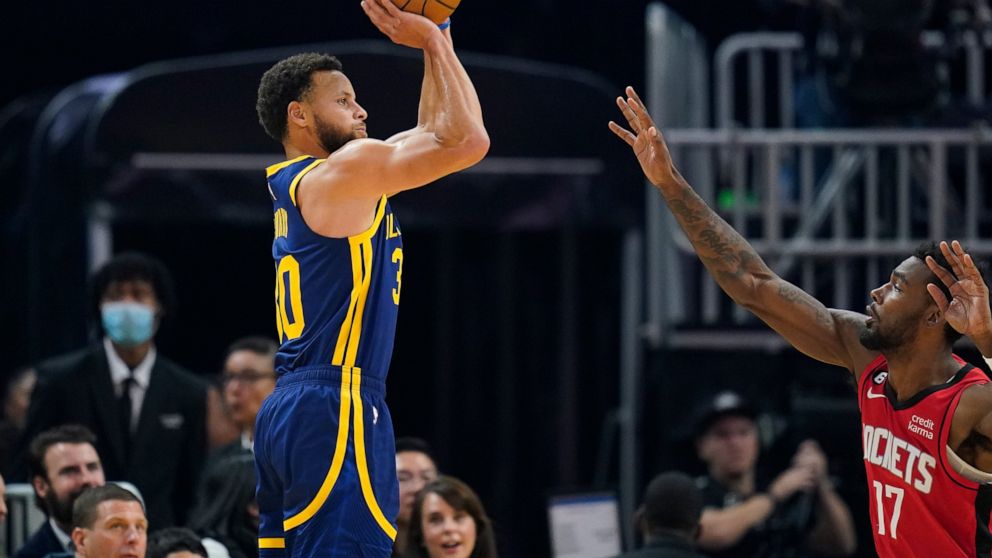 Golden State Warriors guard Stephen Curry, left, shoots a 3-point basket over Houston Rockets forward Tari Eason (17) during the first half of an NBA basketball game in San Francisco, Saturday, Dec. 3, 2022. (AP Photo/Godofredo A. Vásquez)