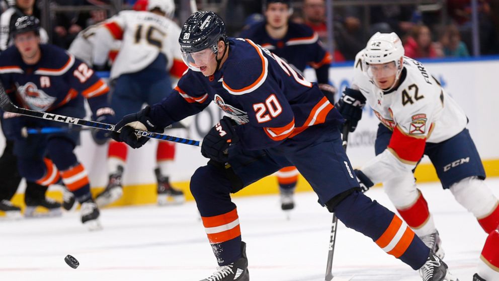 New York Islanders forward Hudson Fasching (20) is trailed by Florida Panthers defenseman Gustav Forsling (42) during the second period of an NHL hockey game Friday, Dec. 23, 2022, in Elmont, N,Y. (AP Photo/John Munson)