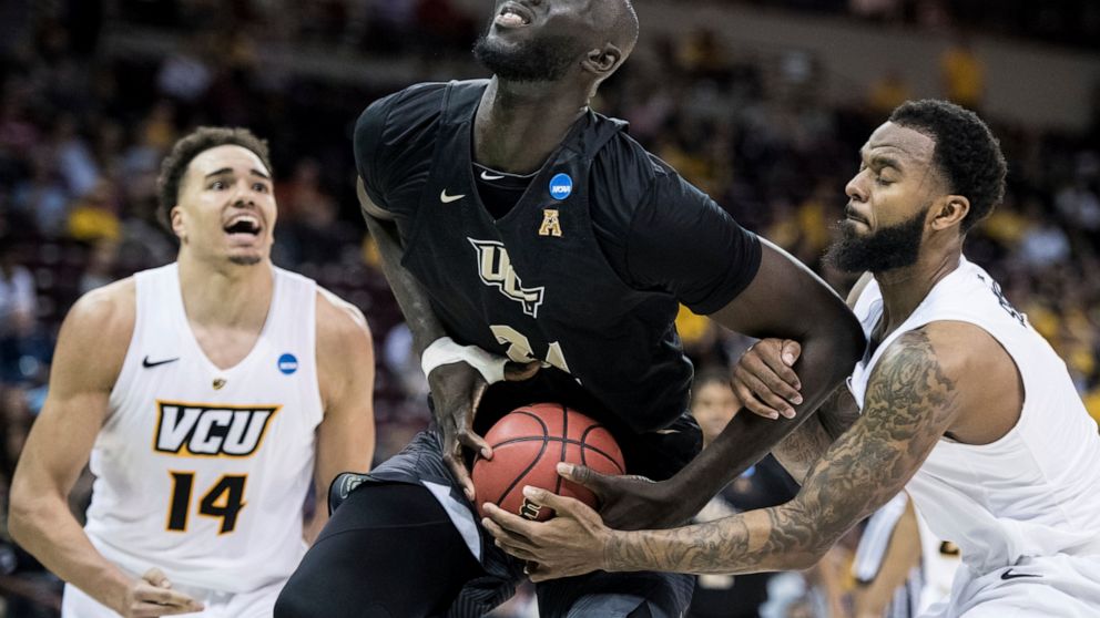 FILE- In this March 22, 2019 file photo, Central Florida center Tacko Fall (24) is fouled by VCU guard Mike'L Simms, right, during the second half of a first-round game in the NCAA men's college basketball tournament in Columbia, S.C. The NBA has pic