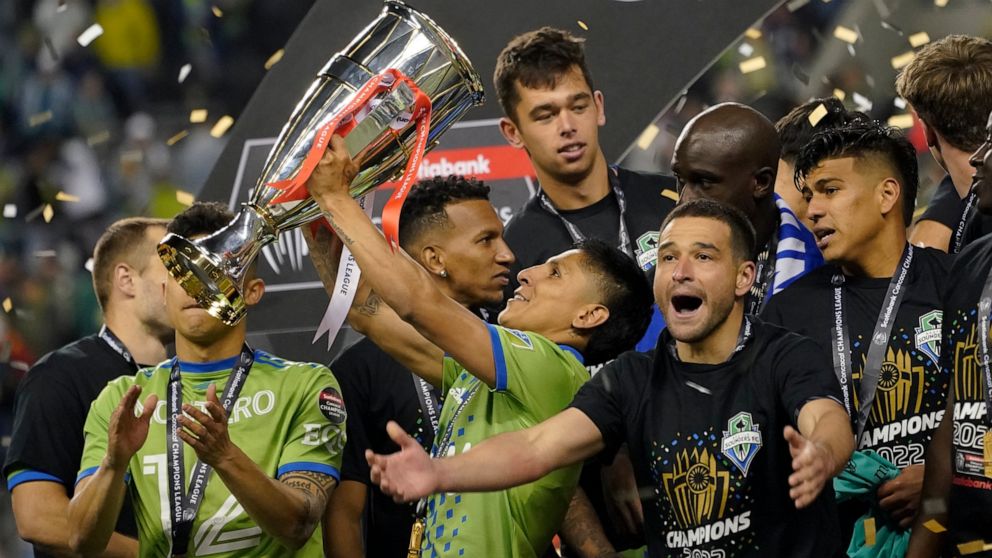 United States' Seattle Sounders forward Raul Ruidiaz holds the trophy alongside teammate midfielder Nicolás Lodeiro after the Sounders defeated Mexico's Pumas to win the CONCACAF Champions League soccer final Wednesday, May 4, 2022, in Seattle. (AP P