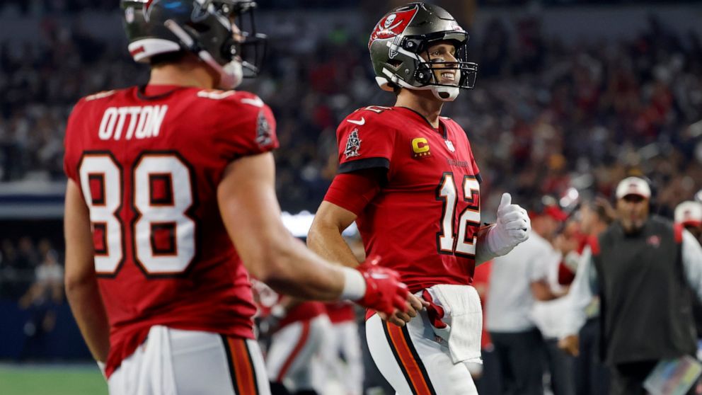 Tampa Bay Buccaneers tight end Cade Otton (88) and quarterback Tom Brady (12) celebrate after Mike Evans caught a touchdown pass in the second half of a NFL football game against the Dallas Cowboys in Arlington, Texas, Sunday, Sept. 11, 2022. (AP Pho