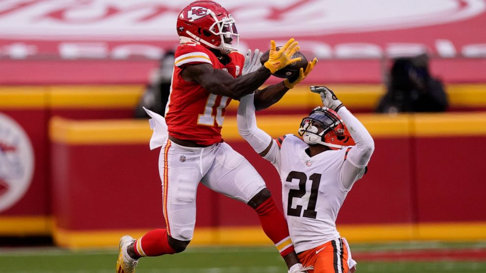 FILE - Kansas City Chiefs wide receiver Tyreek Hill makes a catch over Cleveland Browns cornerback Denzel Ward (21) during the second half of an NFL divisional round football game, Sunday, Jan. 17, 2021, in Kansas City. The Kansas City Chiefs traded 