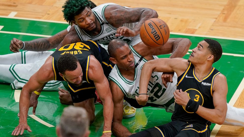 Boston Celtics center Al Horford (42) and guard Marcus Smart, top, battle for a loose ball against Golden State Warriors guard Jordan Poole (3) and guard Stephen Curry (30) during the fourth quarter of Game 3 of basketball's NBA Finals, Wednesday, Ju