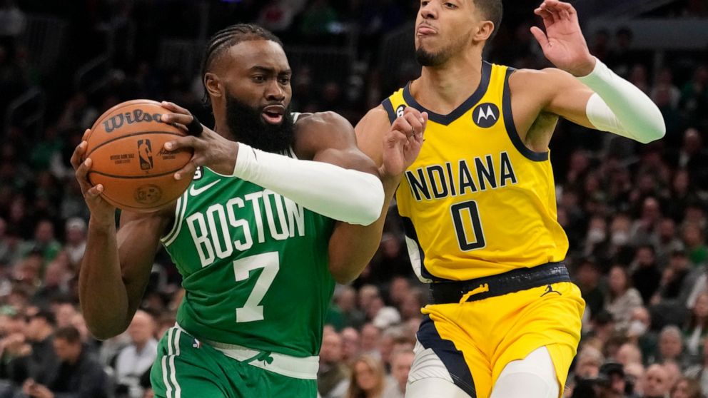 Boston Celtics guard Jaylen Brown (7) drives to the basket against Indiana Pacers guard Tyrese Haliburton during the first half of an NBA basketball game, Wednesday, Dec. 21, 2022, in Boston. (AP Photo/Charles Krupa)