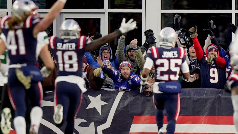 New England Patriots fans celebrate as cornerback Marcus Jones (25) scores on a punt return during the final minute of the second half of an NFL football game against the New York Jets, Sunday, Nov. 20, 2022, in Foxborough, Mass. The Patriots won 10-