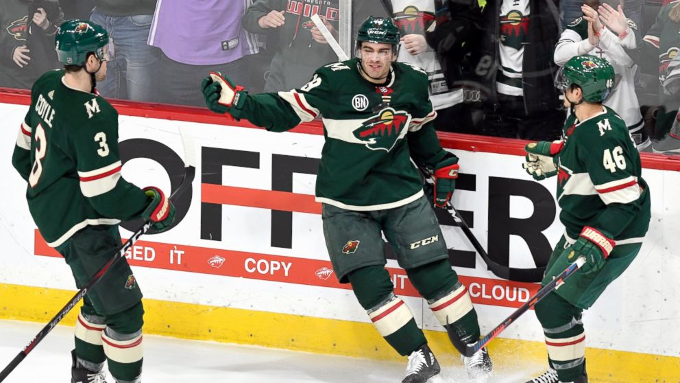Minnesota Wild's Charlie Coyle (3) and Jared Spurgeon (46) move in to celebrate the goal of Luke Kunin, center, against the Detroit Red Wings in the first period of an NHL hockey game Saturday, Jan. 12, 2019, in St. Paul, Minn. (AP Photo/Tom Olmscheid)