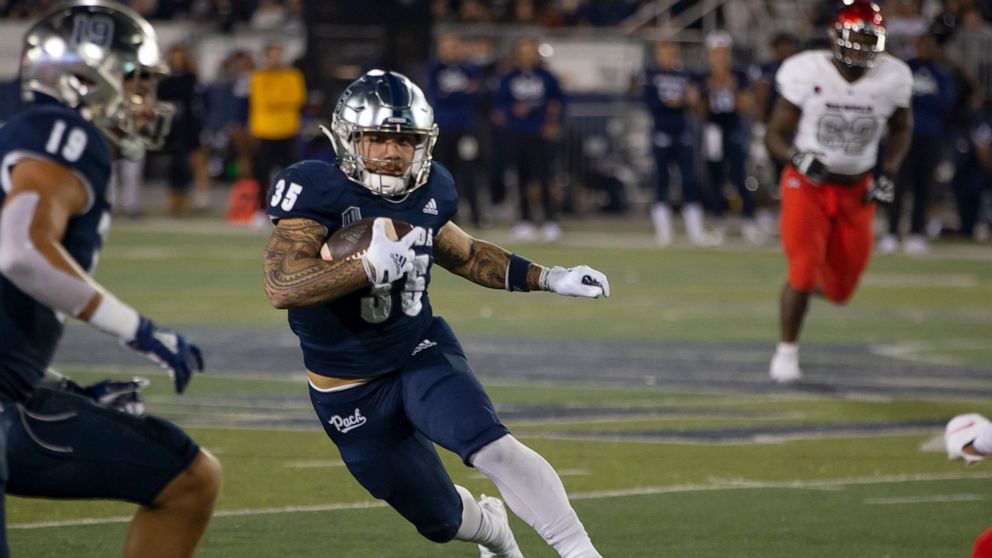 Nevada running back Toa Taua (35) carries against UNLV during the first half of an NCAA college football game in Reno, Nev., Friday, Oct. 29, 2021. (AP Photo/Tom R. Smedes)