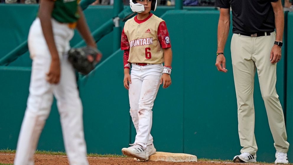 Santa Clara, Utah's Brogan Oliverson (6) stands on first base as a pinch runner during the fifth inning of a baseball game against Davenport, Iowa, at the Little League World Series in South Williamsport, Pa., Sunday, Aug. 21, 2022. (AP Photo/Gene J.