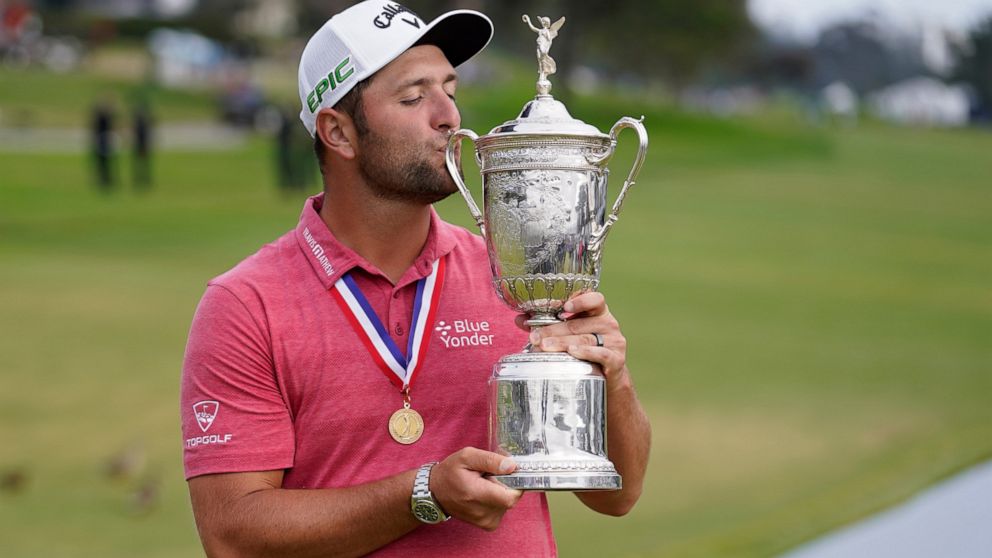 FILE - Jon Rahm, of Spain, kisses the champions trophy for photographers after the final round of the U.S. Open Golf Championship, Sunday, June 20, 2021, at Torrey Pines Golf Course in San Diego. Golf has been moving toward youth for some time now, a