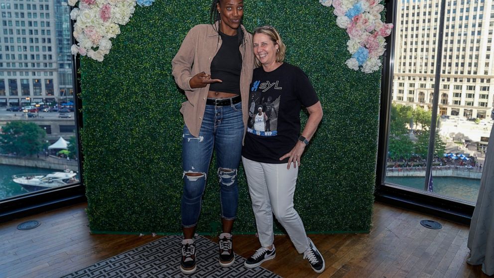 In a photo provided by the Minnesota Lynx, Minnesota Lynx's Sylvia Fowles, left, poses for a photo with Lynx coach Cheryl Reeve at a tea party Saturday, July 9, 2022, at a hotel in Chicago. (Francisco Manzano-Arechiga/Minnesota Lynx via AP)