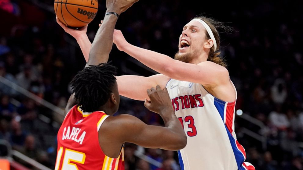 Detroit Pistons forward Kelly Olynyk (13) shoots over the defense of Atlanta Hawks center Clint Capela (15) during the first half of an NBA basketball game, Wednesday, March 23, 2022, in Detroit. (AP Photo/Carlos Osorio)