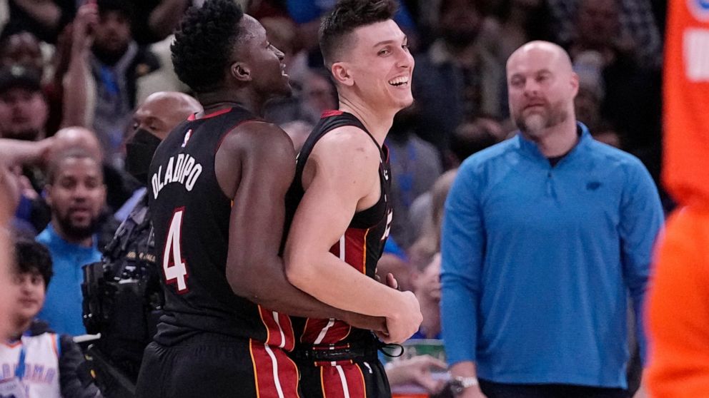 Miami Heat guard Tyler Herro, right, celebrates with teammate, Victor Oladipo, left, after the Miami Heat defeated the Oklahoma City Thunder in an NBA basketball game Wednesday, Dec. 14, 2022, in Oklahoma City. (AP Photo/Sue Ogrocki)