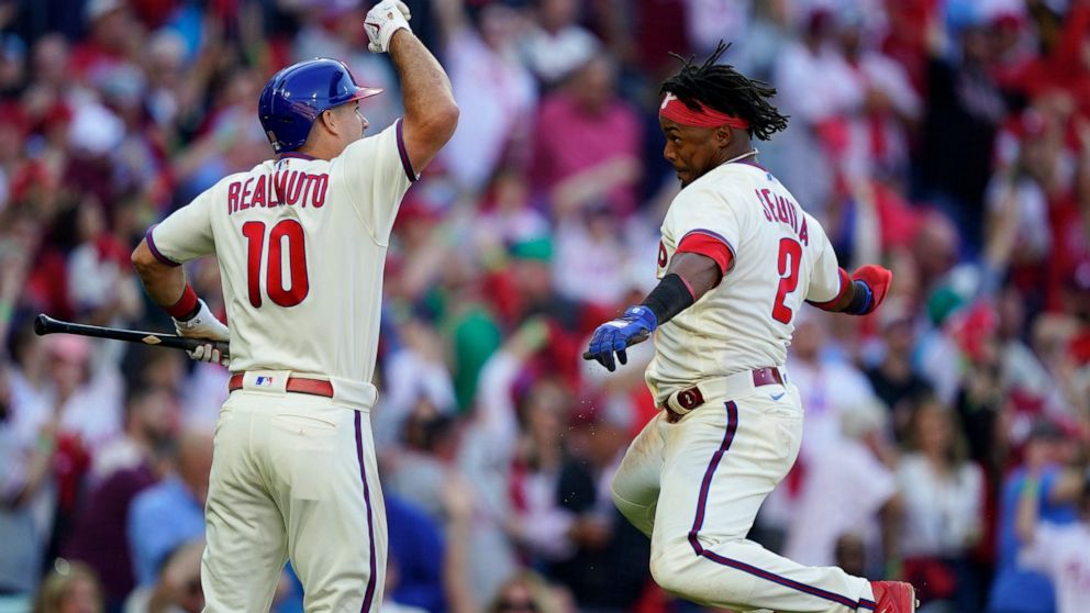 Philadelphia Phillies J.T. Realmuto (10) celebrates with Philadelphia Phillies Jean Segura (2) after Realmuto's RBI-single during the sixth inning in Game 4 of baseball's National League Division Series between the Philadelphia Phillies and the Atlan