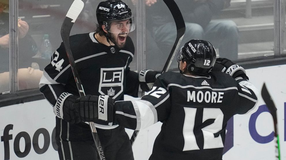 Los Angeles Kings center Phillip Danault (24) celebrates with left wing Trevor Moore (12) after scoring during the third period of an NHL hockey game against the Calgary Flames Thursday, Dec. 22, 2022, in Los Angeles. (AP Photo/Ashley Landis)