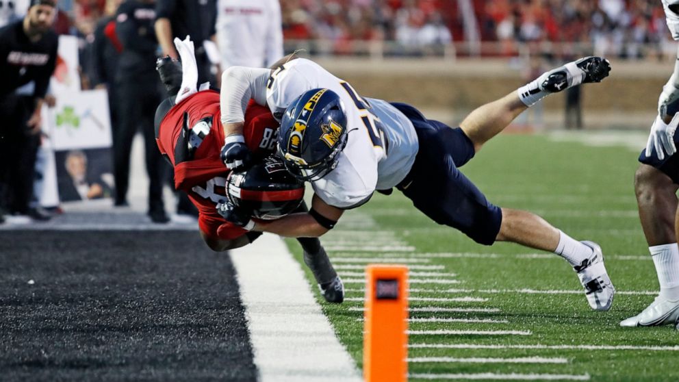 Murray State's Andrew Long (56) tackles Texas Tech's Tahj Brooks (28) during the first half of an NCAA college football game Saturday, Sept. 3, 2022, in Lubbock, Texas. (AP Photo/Brad Tollefson)