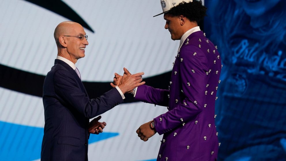 Paolo Banchero, right, is congratulated by NBA Commissioner Adam Silver after being selected as the number one pick overall by the Orlando Magic in the NBA basketball draft, Thursday, June 23, 2022, in New York. (AP Photo/John Minchillo)