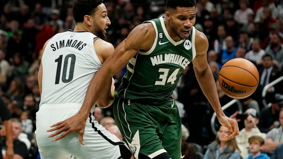 Milwaukee Bucks' Giannis Antetokounmpo (34) and Brooklyn Nets' Ben Simmons (10) go after the ball during the second half of an NBA basketball game Wednesday, Oct. 26, 2022, in Milwaukee. The Bucks won 110-99. (AP Photo/Morry Gash)