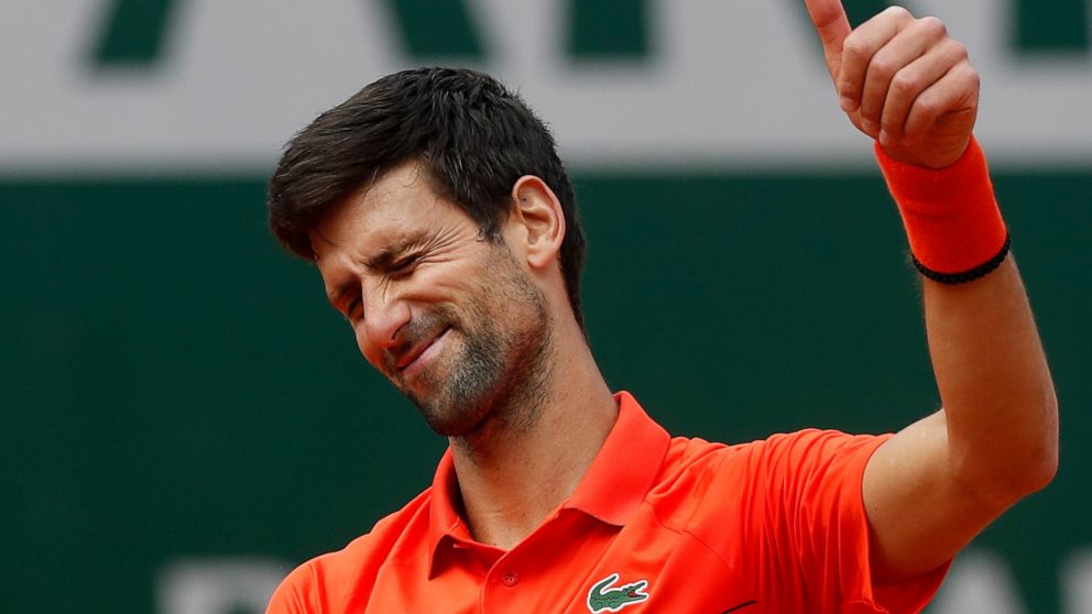 Serbia's Novak Djokovic flashes a thumbs up as he celebrates winning his first round match of the French Open tennis tournament in three sets 6-4, 6-2, 6-2, against Poland's Hubert Hurkacz at the Roland Garros stadium in Paris, Monday, May 27, 2019. 