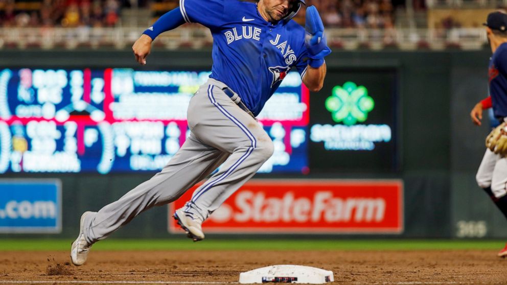 Toronto Blue Jays' Whit Merrifield rounds third and scores from second base against the Minnesota Twins on a two-run single by George Springer during the eighth inning of a baseball game Thursday, Aug. 4, 2022, in Minneapolis. (AP Photo/Bruce Kluckhohn)