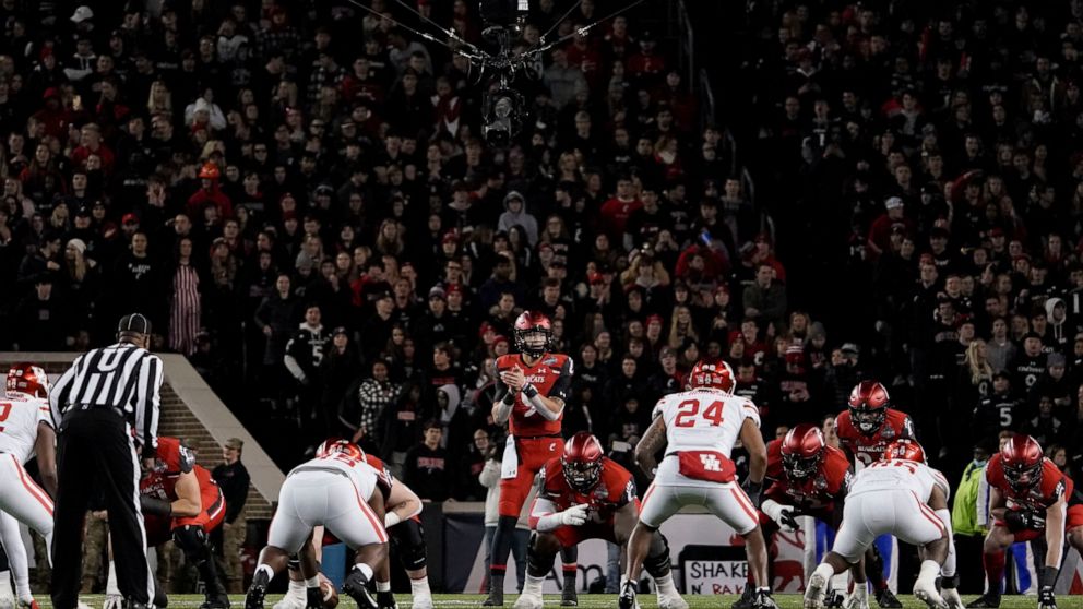 FILE - Cincinnati quarterback Desmond Ridder prepares to take the snap during the second half of an American Athletic Conference championship NCAA college football game against Houston on Dec. 4, 2021, in Cincinnati. The American Athletic Conference 