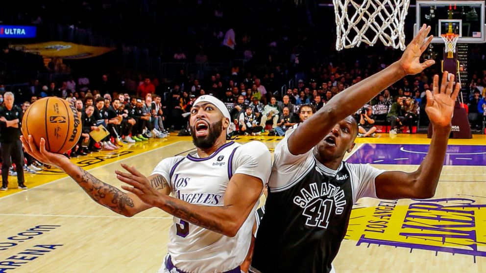 Los Angeles Lakers forward Anthony Davis, left, shoots under pressure from San Antonio Spurs forward Gorgui Dieng during the first half of an NBA basketball game, Sunday, Nov. 20, 2022, in Los Angeles. (AP Photo/Ringo H.W. Chiu)