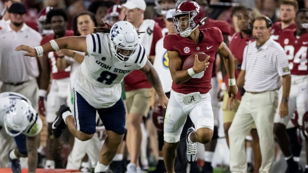 Alabama quarterback Bryce Young, front right, runs with the ball against Utah State defensive lineman Hale Motu'apuaka (8) during the first half of an NCAA college football game Saturday, Sept. 3, 2022, in Tuscaloosa, Ala. (AP Photo/Vasha Hunt)