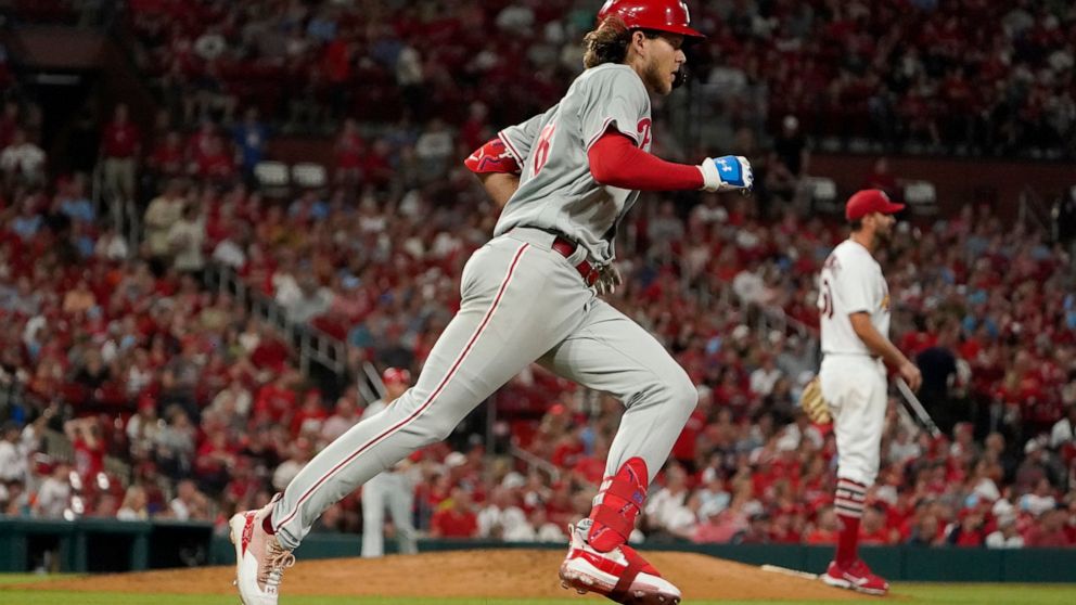 Philadelphia Phillies' Alec Bohm, left, rounds the bases after hitting a solo home run off St. Louis Cardinals starting pitcher Adam Wainwright during the sixth inning of a baseball game Friday, July 8, 2022, in St. Louis. (AP Photo/Jeff Roberson)