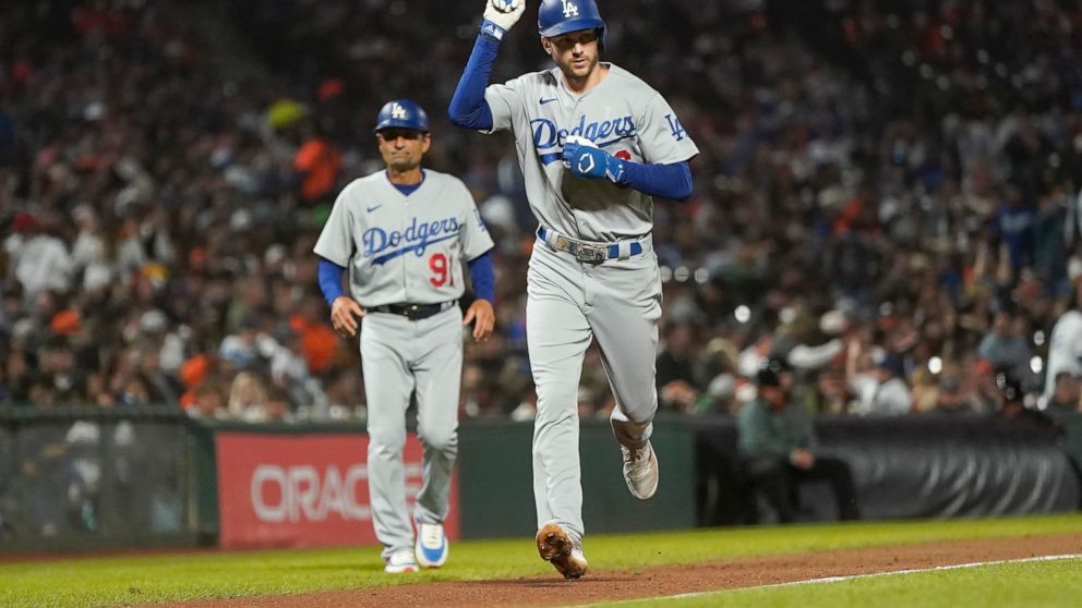 Los Angeles Dodgers' Trea Turner gestures in front of third base coach Dino Ebel (91) after hitting a home run against the San Francisco Giants during the seventh inning of a baseball game in San Francisco, Monday, Aug. 1, 2022. (AP Photo/Jeff Chiu)