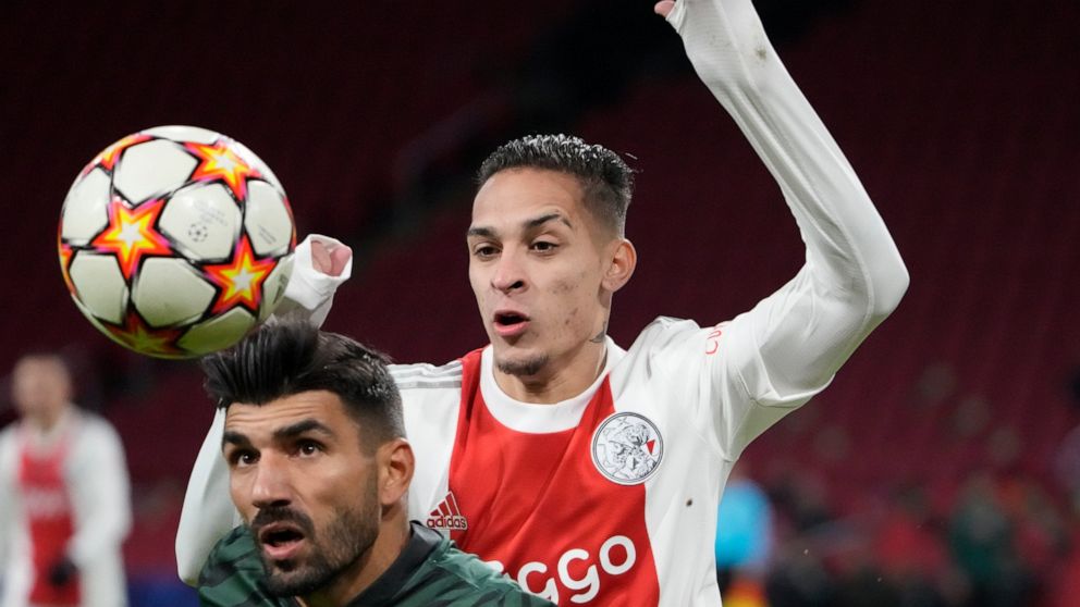 FILE - Sporting's Ricardo Esgaio, left, and Ajax's Antony jump for the ball during a Champions League group C soccer match between Ajax and Sporting CP, at the at the Johan Cruyff ArenA in Amsterdam, Netherlands, on Dec. 7, 2021. Brazil winger Antony