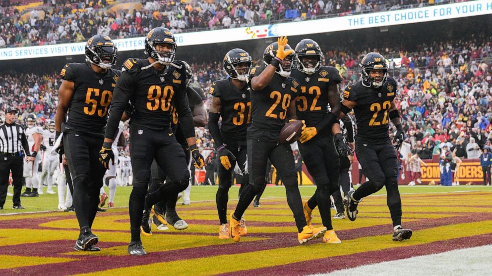 Washington Commanders cornerback Kendall Fuller (29) celebrating his interception against the Atlanta Falcons with his teammates near the end of the second half of an NFL football game, Sunday, Nov. 27, 2022, in Landover, Md. Washington won 13-19. (A