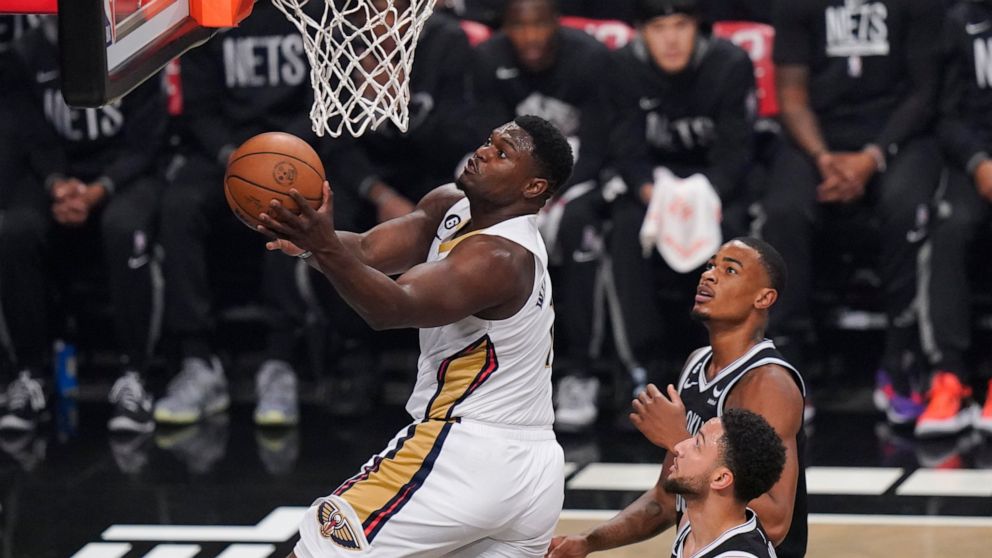 New Orleans Pelicans' Zion Williamson, left, drives past Brooklyn Nets' Nic Claxton, top right, and Ben Simmons during the first half of an NBA basketball game Wednesday, Oct. 19, 2022 in New York. (AP Photo/Frank Franklin II)