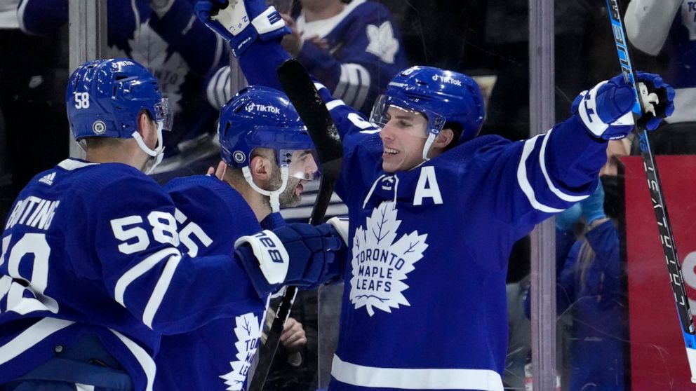 Toronto Maple Leafs right wing Mitchell Marner (16) celebrates his goal with teammates Michael Bunting (58) and Mark Giordano (55) during first period NHL hockey game in Toronto, Sunday, April 17, 2022. (Frank Gunn/The Canadian Press via AP)