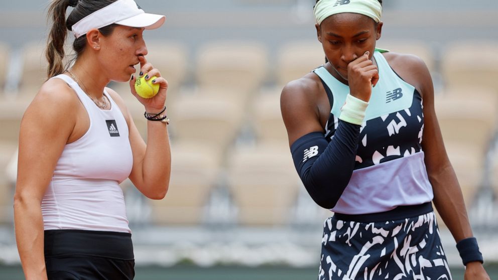 Coco Gauff of the U.S., right, and Jessica Pegula of the U.S. talk as they play France's Caroline Garcia and France's Kristina Mladenovic during their women doubles final match of the French Open tennis tournament at the Roland Garros stadium Sunday,
