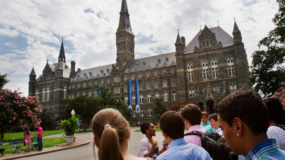 FILE - Prospective students tour Georgetown University's campus, on July 10, 2013, in Washington. Amin Khoury is scheduled to stand trial Tuesday June 7, 2022, in Boston, on charges that he bribed Georgetown University tennis coach Gordon Ernst to ge