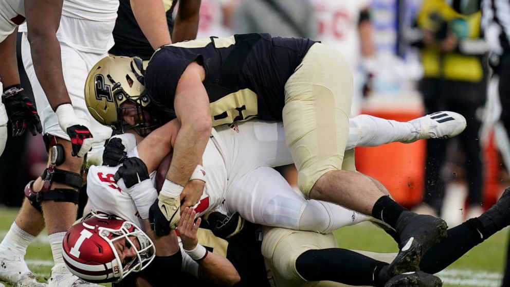 Indiana quarterback Grant Gremel (16) is sacked by Purdue's George Karlaftis (5) and Jack Sullivan (99) during the first half of an NCAA college football game, Saturday, Nov. 27, 2021, in West Lafayette, Ind.(AP Photo/Darron Cummings)