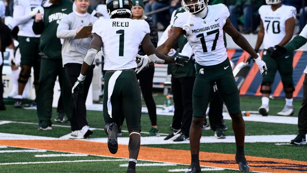 Michigan State wide receiver Tre Mosley (17) high-fives wide receiver Jayden Reed (1) after Reed scored a touchdown against Illinois during the second half of an NCAA college football game, Saturday, Nov. 5, 2022, in Champaign, Ill. (AP Photo/Matt Marton)