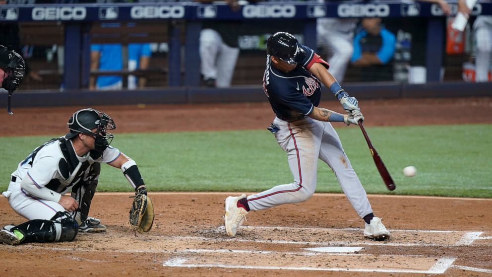 Atlanta Braves' Vaughn Grissom gets a base hit as Miami Marlins catcher Nick Fortes looks on during the third inning of a baseball game, Sunday, Aug. 14, 2022, in Miami. (AP Photo/Wilfredo Lee)