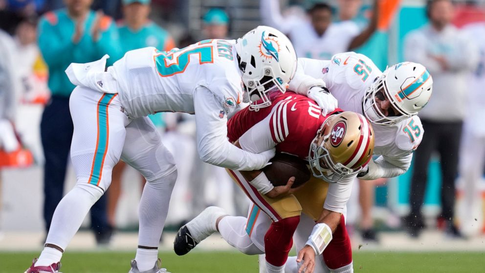 San Francisco 49ers quarterback Jimmy Garoppolo, middle, is sacked by Miami Dolphins linebacker Jerome Baker, left, and linebacker Jaelan Phillips (15) during the first half of an NFL football game in Santa Clara, Calif., Sunday, Dec. 4, 2022. (AP Ph