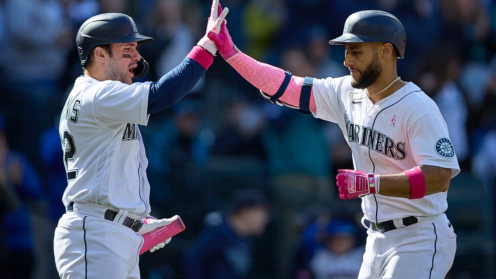 Seattle Mariners' Abraham Toro, right, is greeted at home plate by Luis Torrens after hitting a solo home run against the Tampa Bay Rays during the ninth inning of a baseball game, Sunday, May 8, 2022, in Seattle. (AP Photo/John Froschauer)