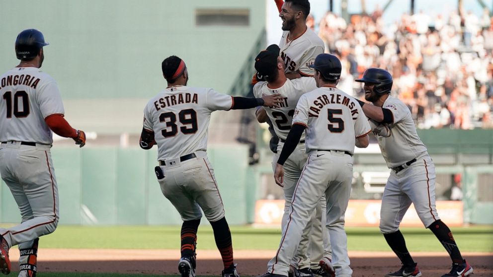 San Francisco Giants' David Villar, top, is congratulated by teammates after hitting a two-run single against the Arizona Diamondbacks during the 10th inning of a baseball game in San Francisco, Sunday, Oct. 2, 2022. (AP Photo/Jeff Chiu)