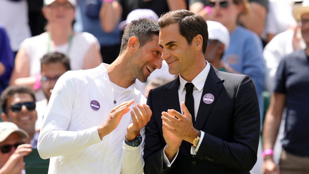 Serbia's Novak Djokovic and Switzerland's Roger Federer speak during a 100 years of Centre Court celebration on day seven of the Wimbledon tennis championships in London, Sunday, July 3, 2022. (AP Photo/Kirsty Wigglesworth)
