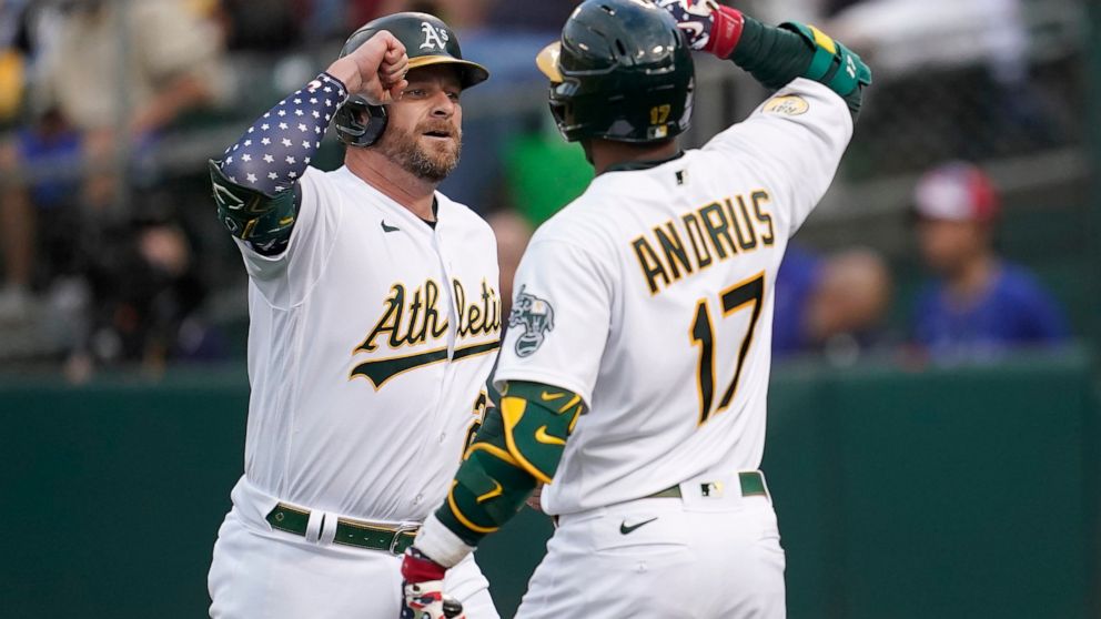 Oakland Athletics' Stephen Vogt, left, is congratulated by Elvis Andrus after hitting a home run against the Toronto Blue Jays during the sixth inning of a baseball game in Oakland, Calif., Monday, July 4, 2022. (AP Photo/Jeff Chiu)
