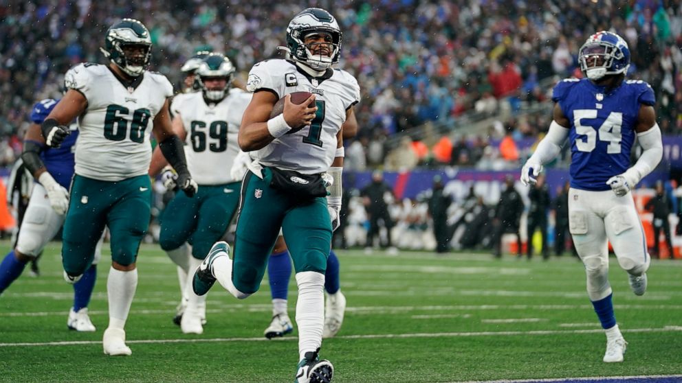 Philadelphia Eagles quarterback Jalen Hurts (1) scores a touchdown against the New York Giants during the third quarter of an NFL football game, Sunday, Dec. 11, 2022, in East Rutherford, N.J. (AP Photo/Bryan Woolston)