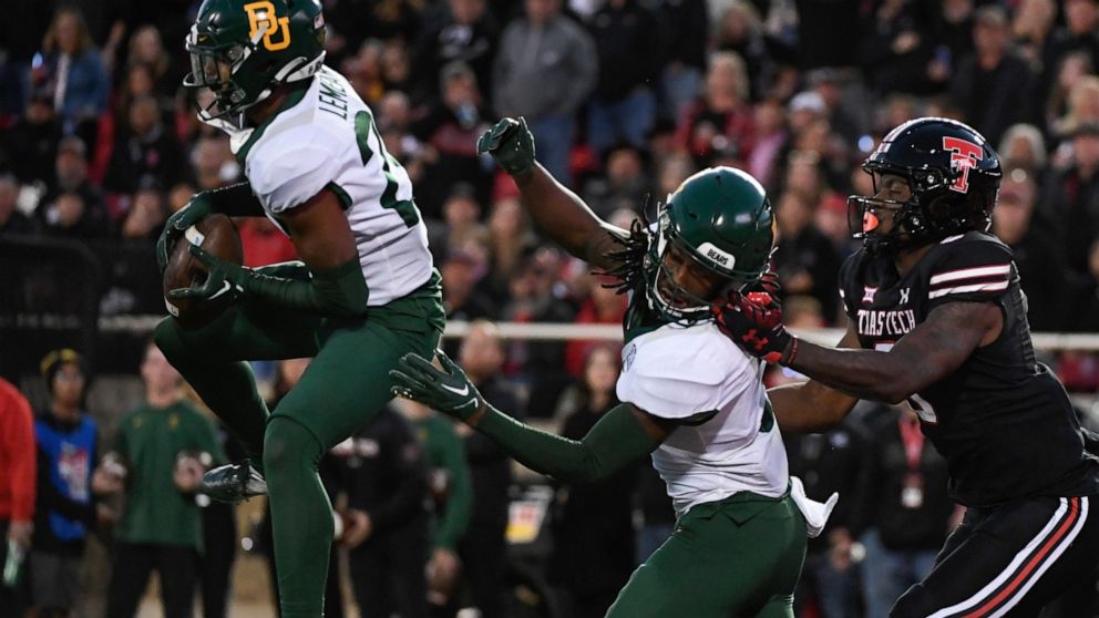 Baylor safety Devin Lemear, left, intercepts a pass intended for Texas Tech wide receiver J.J. Sparkman, right, while Baylor linebacker Matt Jones, center, defends during the first half of an NCAA college football game Saturday, Oct. 29, 2022, in Lub