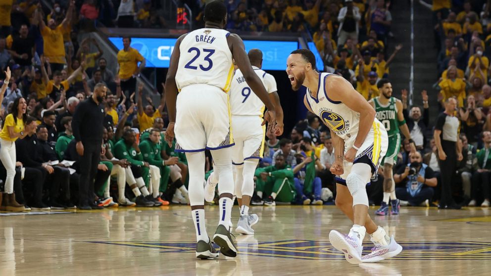 Golden State Warriors guard Stephen Curry, right, celebrates with forward Draymond Green (23) during the first half of Game 1 of basketball's NBA Finals against the Boston Celtics in San Francisco, Thursday, June 2, 2022. (AP Photo/Jed Jacobsohn)
