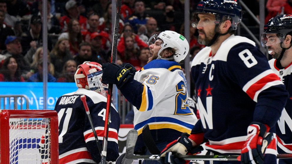 St. Louis Blues left wing Nathan Walker (26) celebrates his goal next to Washington Capitals goaltender Vitek Vanecek (41) and left wing Alex Ovechkin (8) during the second period of an NHL hockey game Tuesday, March 22, 2022, in Washington. (AP Phot